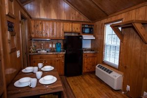 Boo Boo One Room Cabin interior, with dining table, dishes, sink, coffeemaker, refrigerator, and microwave