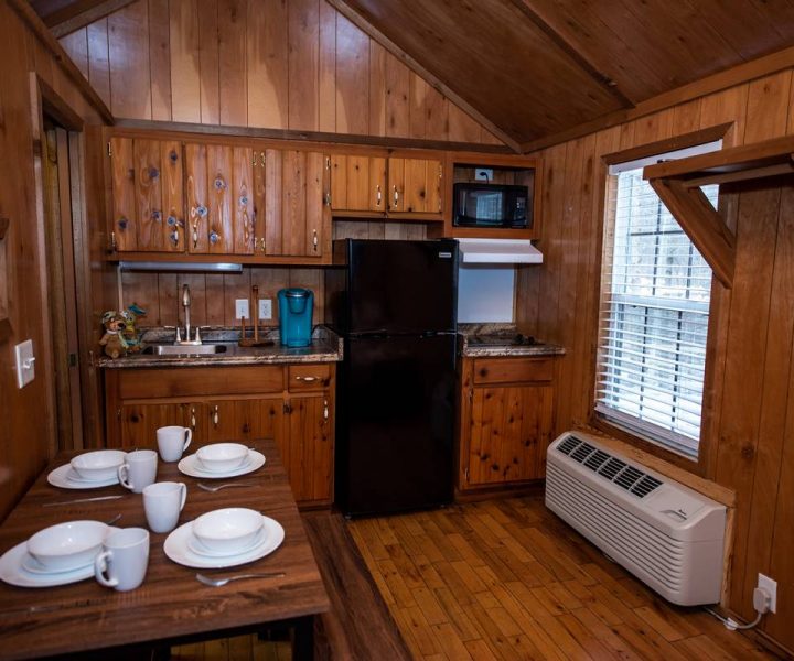 Boo Boo One Room Cabin interior, with dining table, dishes, sink, coffeemaker, refrigerator, and microwave