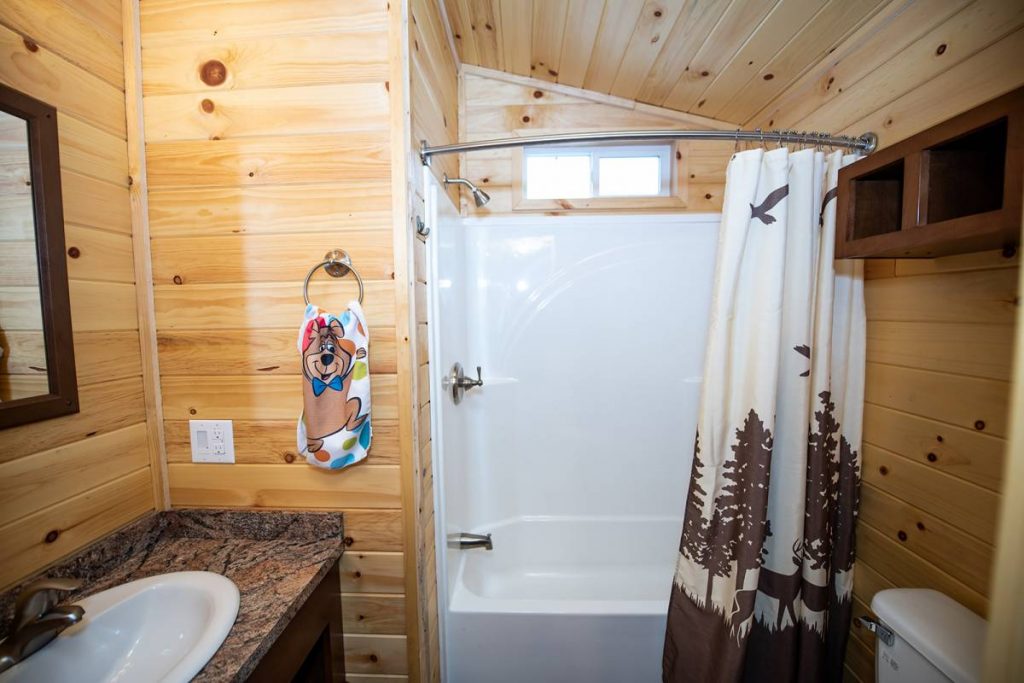 Boo Boo Two Room Cabin interior, bathroom with shower, sink, toilet, and mirror
