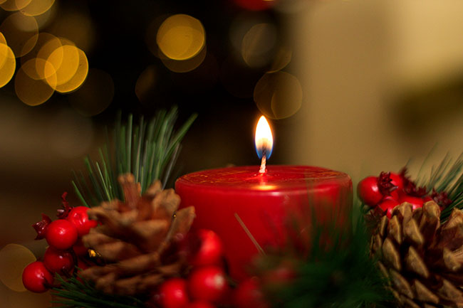 Candle with pinecones and holly