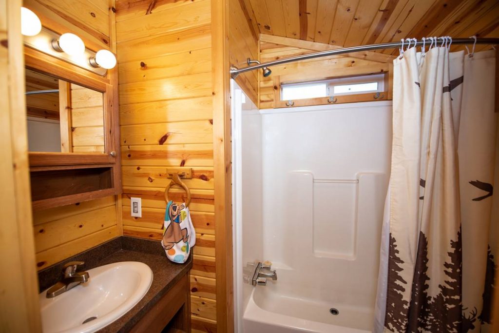 Cindy Bear cabin interior, bathroom with shower, sink, and mirror