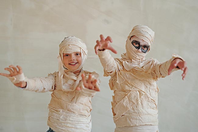 Two children dressed as mummies in bandages