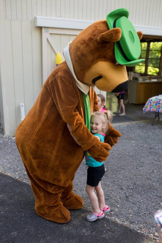 Bear mascot giving a small child a hug