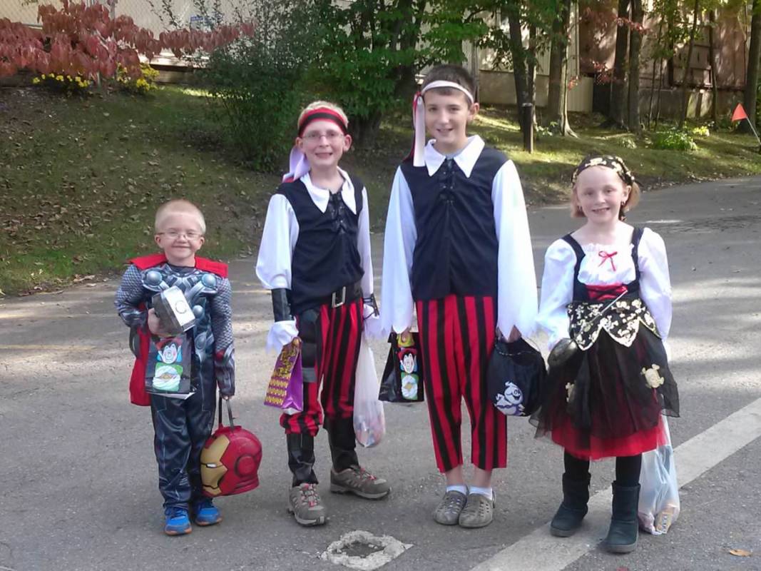 Four children with trick-or-treat bags dressed as pirates (and one dressed as Thor)
