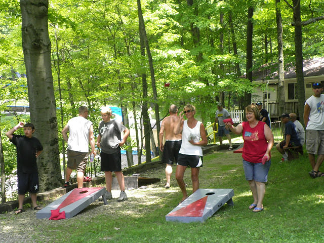 Several campers participating in beanbag toss in the woods