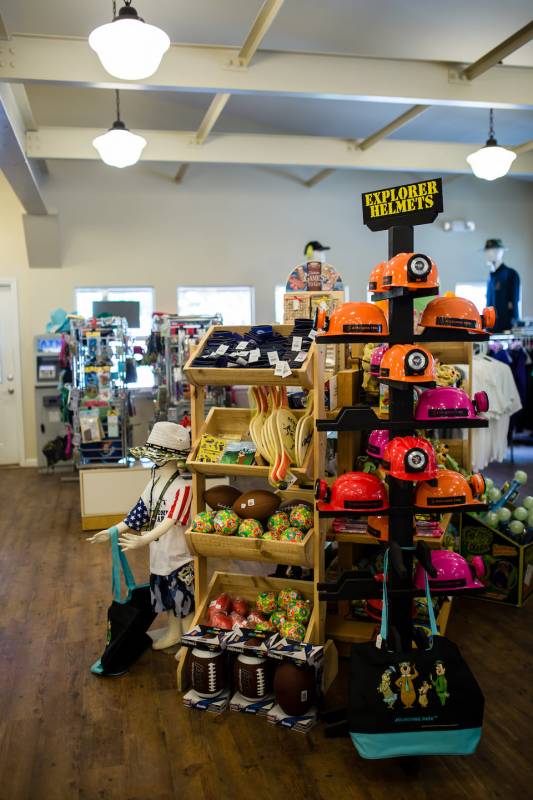 Camp shop with children's toys such as small explorer helmets, paddles, foam balls, and children's clothing