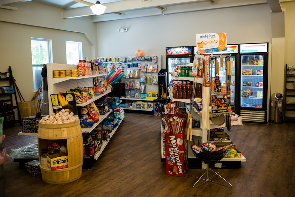 Camp shop interior with various convenience goods such as firewood, snacks, and pool toys