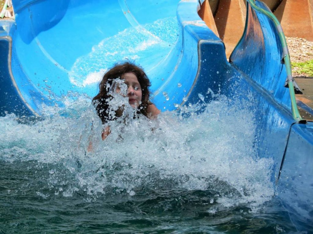 Girl splashing off of waterslide